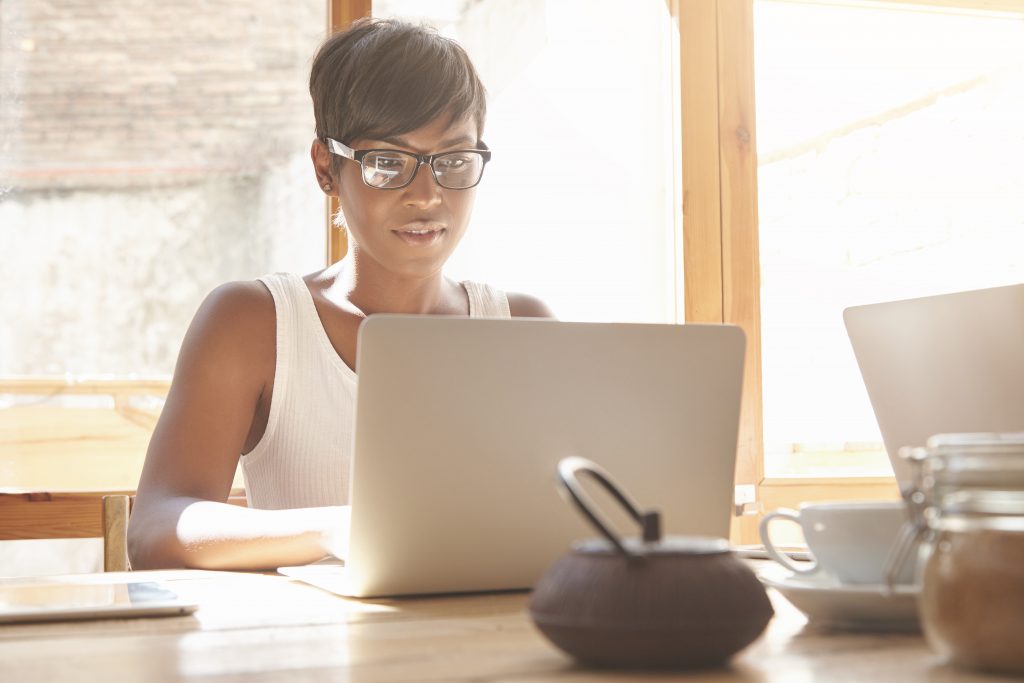 Woman sitting at table using laptop computer